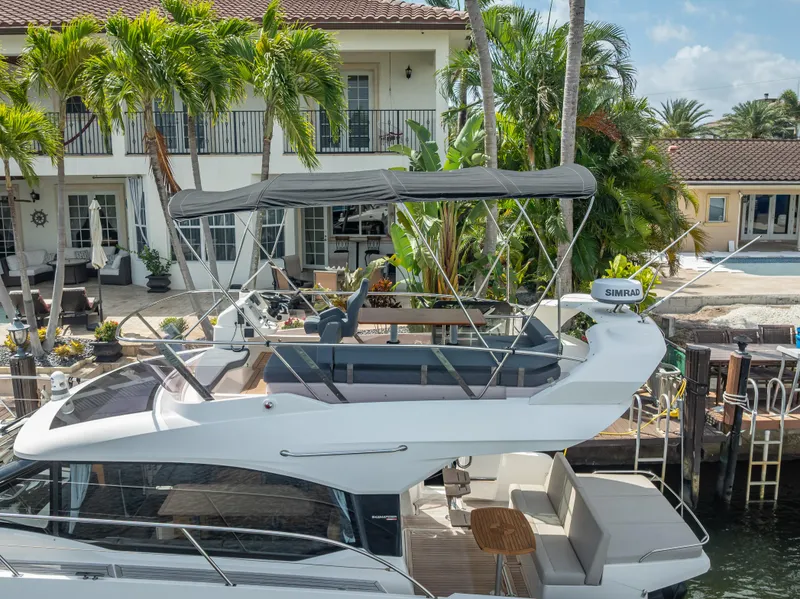 Slide: The Image of 2021 Skamander Monaco yacht docked near a luxurious waterfront home with palm trees. - 36