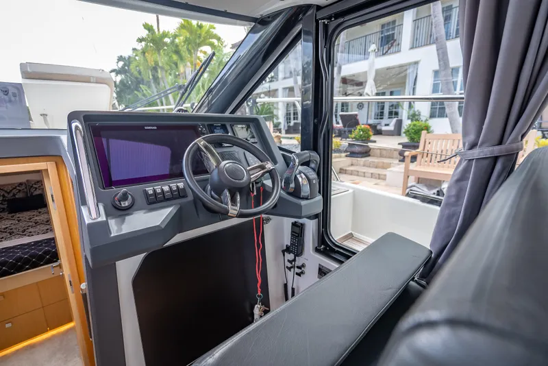 Slide: The Image of Interior of a 2021 Skamander Monaco boat, featuring a modern steering console and seating. - 8