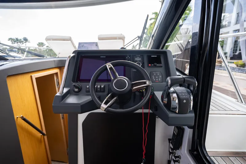 Slide: The Image of 2021 Skamander Monaco boat cockpit with steering wheel and control panel. - 9