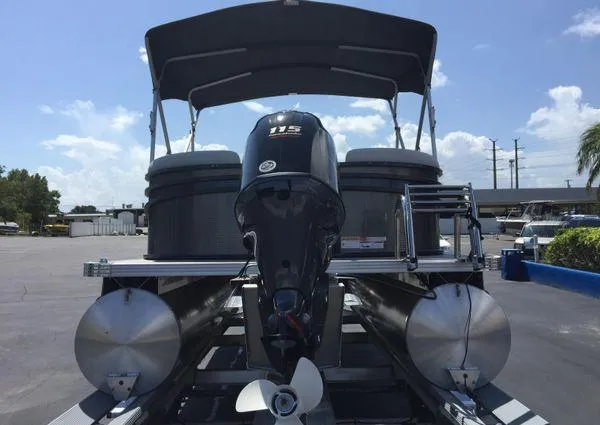 Slide: The Image of 2024 Crest LX 200 SLC pontoon boat with outboard motor, docked under clear blue sky. - 18