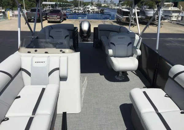 Slide: The Image of 2024 Crest LX 200 SLC pontoon boat interior with seating and helm, docked at marina. - 23