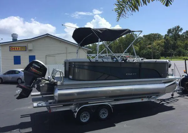 Slide: The Image of 2024 Crest LX 200 SLC pontoon boat on trailer, parked near a deli. - 3
