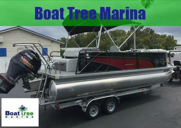 Slide: The Image of 2024 Crest Classic LX 220 SLSC pontoon boat on trailer, black exterior, docked outdoors. - 4