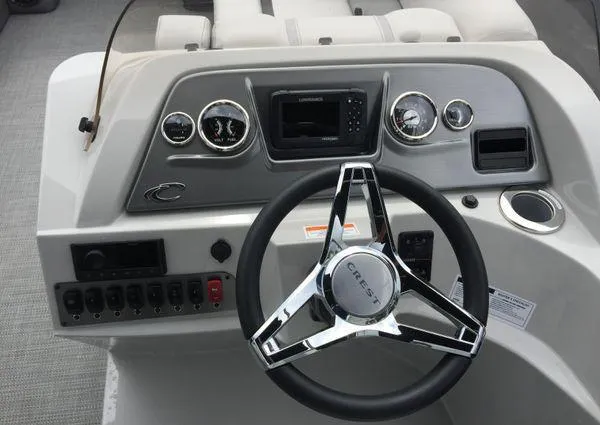 Slide: The Image of 2024 Crest Classic LX 220 SLSC boat interior with white seating and foldable table. - 7