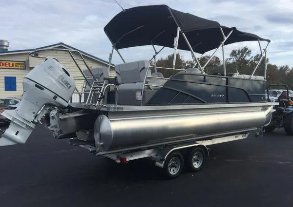 Slide: The Image of 2024 Crest LX 220 SLRC pontoon boat with outboard motor and canopy, parked on trailer. - 3