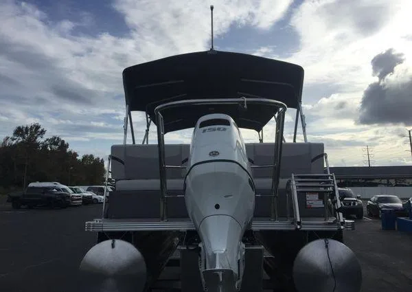 Slide: The Image of 2024 Crest LX 220 SLRC pontoon boat on trailer, parked outdoors under cloudy sky. - 7