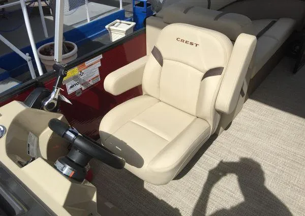 Slide: The Image of 2024 Crest LX 220 SLC boat captain's chair with beige upholstery and steering wheel. - 10