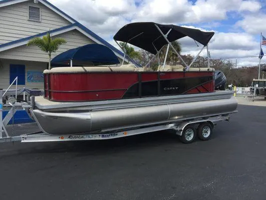 Slide: The Image of 2024 Crest LX 220 SLC pontoon boat on trailer, parked near a building. - 12