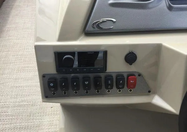 Slide: The Image of Control panel of 2024 Crest LX 220 SLC boat with switches and audio system. - 15