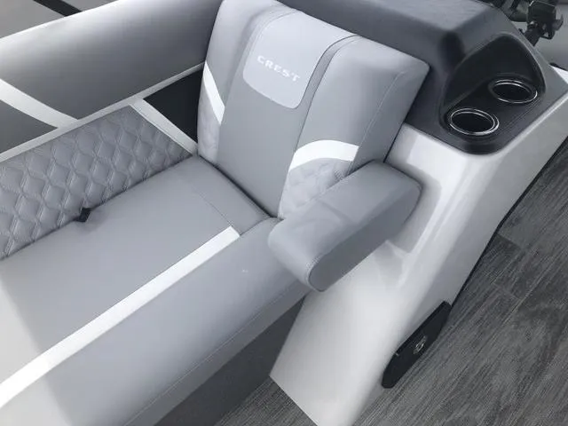 Slide: The Image of 2025 Crest Classic LX 220 SLRC boat with gray seating and wood-style flooring. - 14
