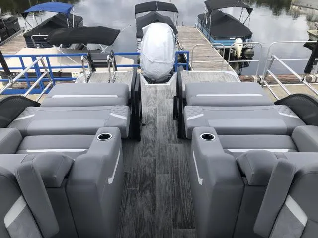 Slide: The Image of 2025 Crest Classic LX 220 SLRC pontoon boat with canopy, parked outdoors. - 15