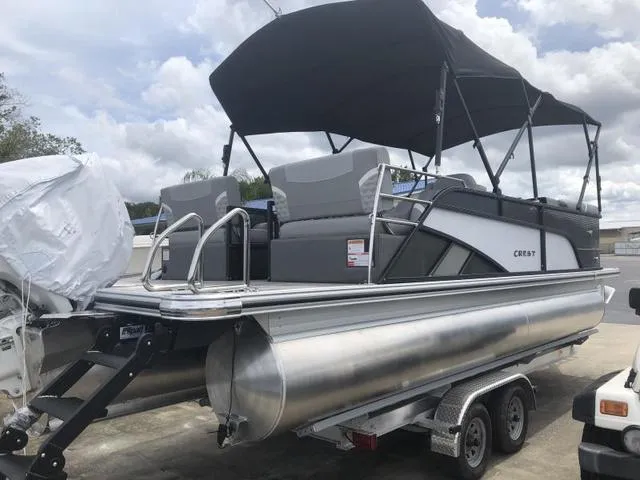 Slide: The Image of 2025 Crest Classic LX 220 SLRC pontoon boat with canopy, docked at marina. - 22