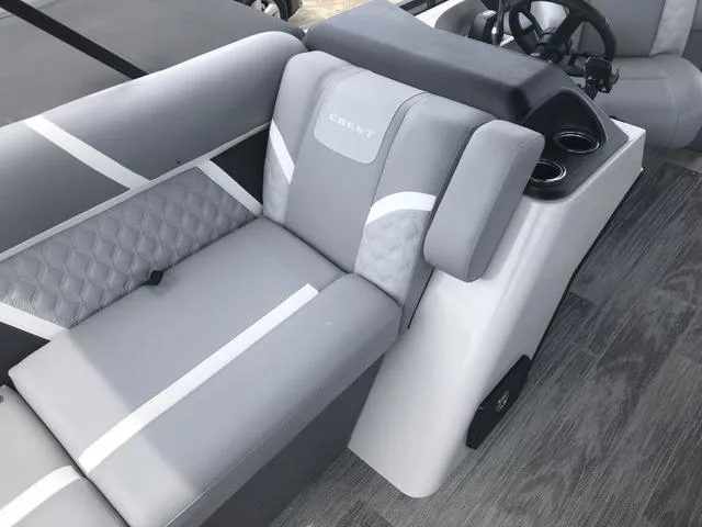 Slide: The Image of 2025 Crest Classic LX 220 SLRC pontoon boat interior with gray seating and cup holders. - 28