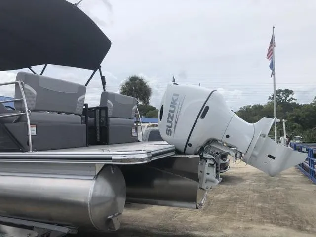 Slide: The Image of 2025 Crest Classic LX 220 SLRC pontoon boat with Suzuki outboard motor, docked outdoors. - 37