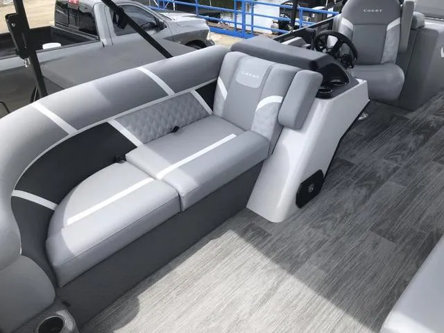 Slide: The Image of 2025 Crest Classic LX 220 SLRC pontoon boat with covered engine and seating area. - 7