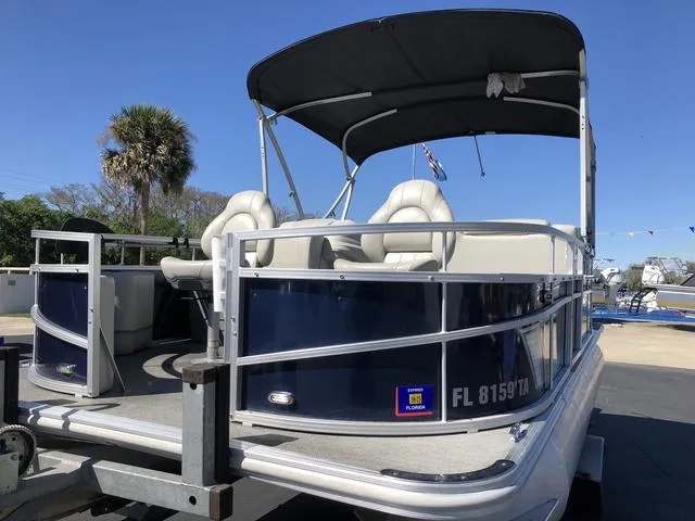 Slide: The Image of 2022 SunChaser Vista 188 Sport Fish pontoon boat with canopy, parked on trailer. - 24