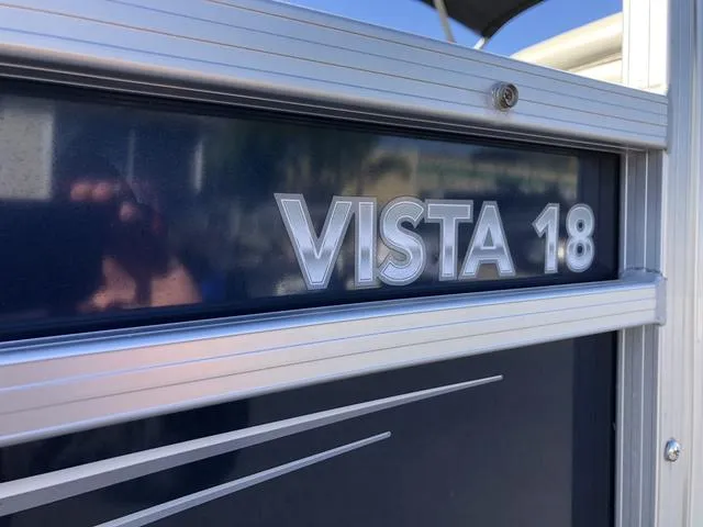 Slide: The Image of 2022 SunChaser Vista 188 Sport Fish boat, close-up of "Vista 18" logo on metallic surface. - 9