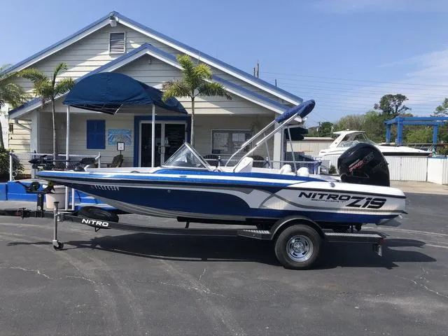 Slide: The Image of 2021 Nitro Z19 Sport boat parked outside a building with palm trees. - 1