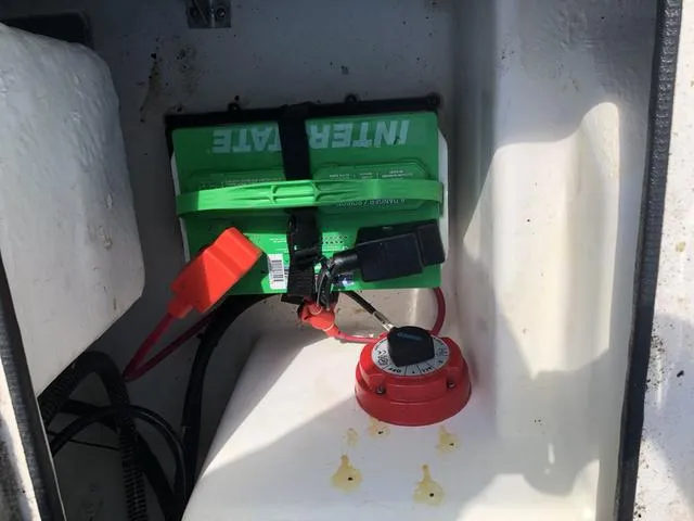 Slide: The Image of Battery compartment of 2021 Nitro Z19 Sport boat with green battery and red switch. - 19