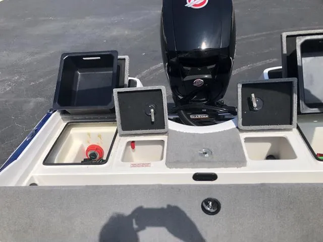 Slide: The Image of 2021 Nitro Z19 Sport boat with open storage compartments and outboard motor. - 23