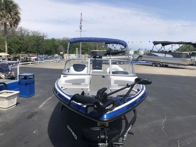 Slide: The Image of 2021 Nitro Z19 Sport boat with blue canopy, parked on a marina lot. - 4
