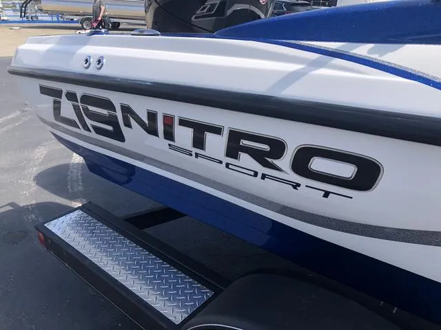 Slide: The Image of 2021 Nitro Z19 Sport boat, close-up of logo and trailer, parked outdoors. - 8