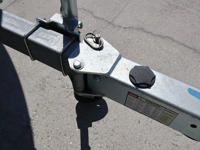 Slide: The Image of Trailer hitch and safety pin on a 2023 Robalo 226 Cayman boat trailer. - 13