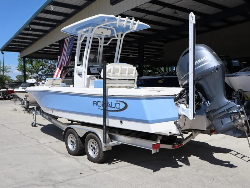 Slide: The Image of 2023 Robalo 226 Cayman boat on trailer with Yamaha engine, parked under a canopy. - 3
