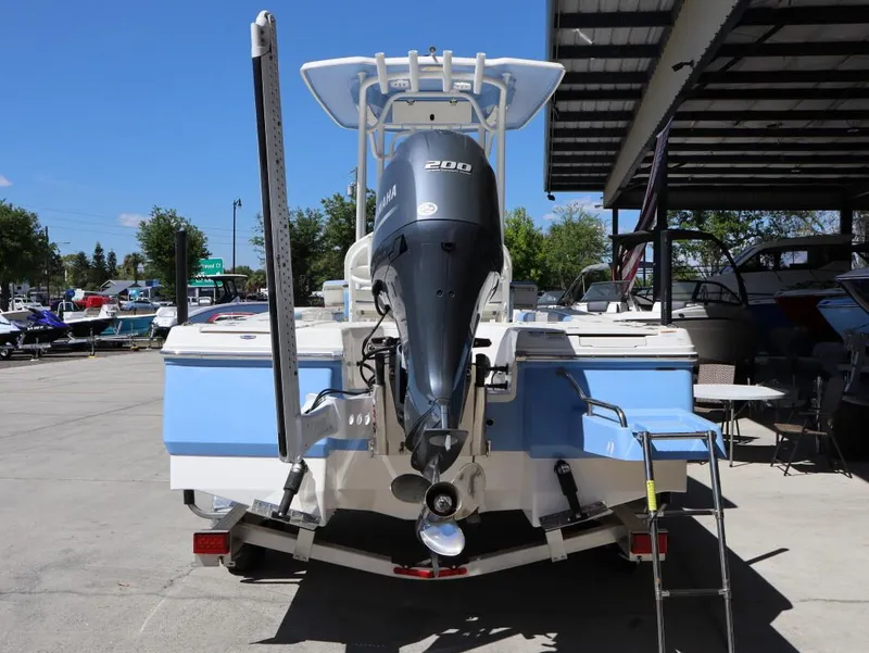 Slide: The Image of 2023 Robalo 226 Cayman boat with Yamaha 200 engine, parked at a marina. - 6