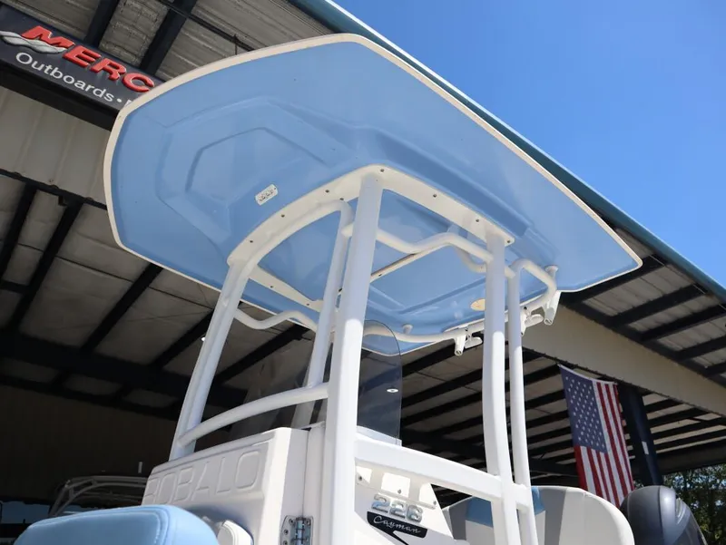 Slide: The Image of 2023 Robalo 226 Cayman boat with blue T-top under clear sky. - 7