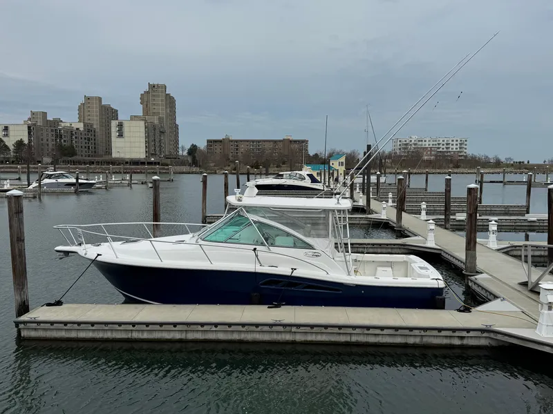Slide: The Image of 2011 Rampage 34 IPS boat docked in a marina with cityscape background. - 10