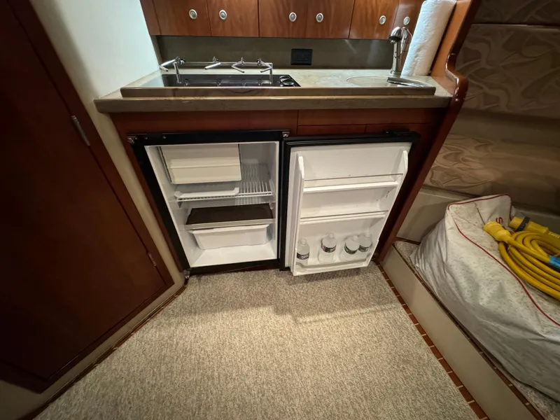 Slide: The Image of Compact kitchen area in a 2011 Rampage 34 IPS boat with open fridge and sink. - 38
