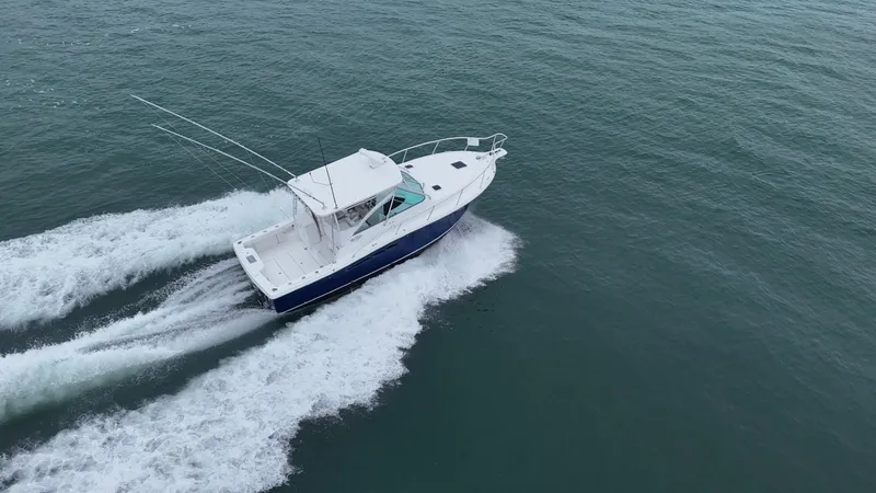 Slide: The Image of 2011 Rampage 34 IPS boat cruising on open water, aerial view. - 5