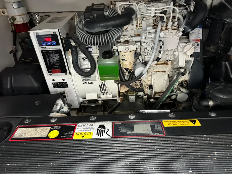 Slide: The Image of Engine compartment of a 2011 Rampage 34 IPS boat, featuring a Kohler generator. - 52