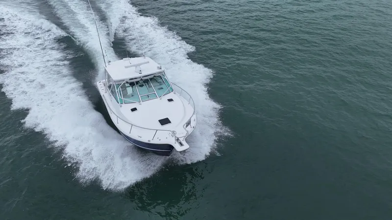 Slide: The Image of 2011 Rampage 34 IPS boat cruising on open water, creating a wake. - 7