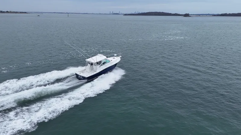 Slide: The Image of 2011 Rampage 34 IPS boat cruising on open water, creating a wake behind. - 9