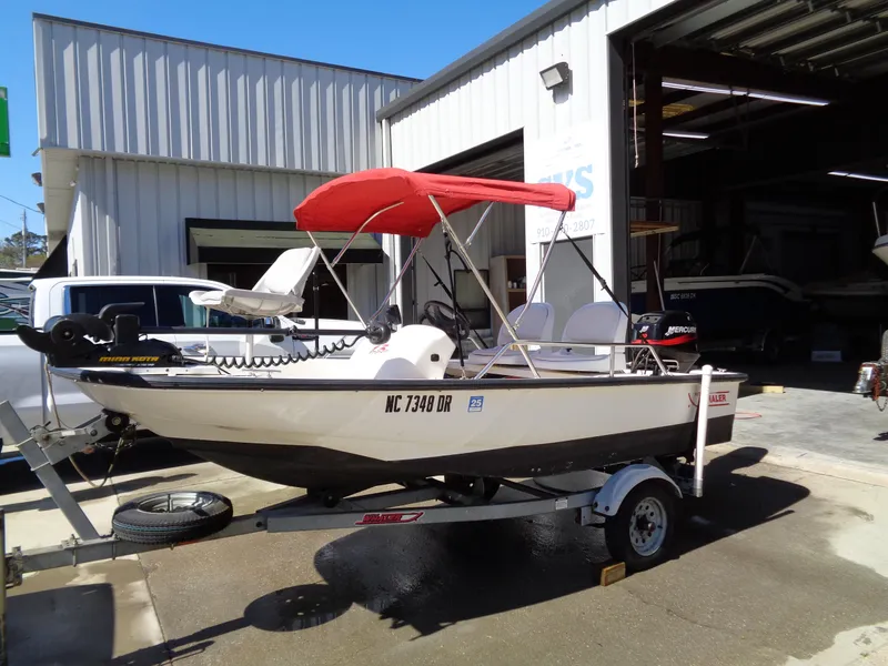 Slide: The Image of 2001 Boston Whaler 13 Sport boat with red canopy on trailer outside garage. - 1