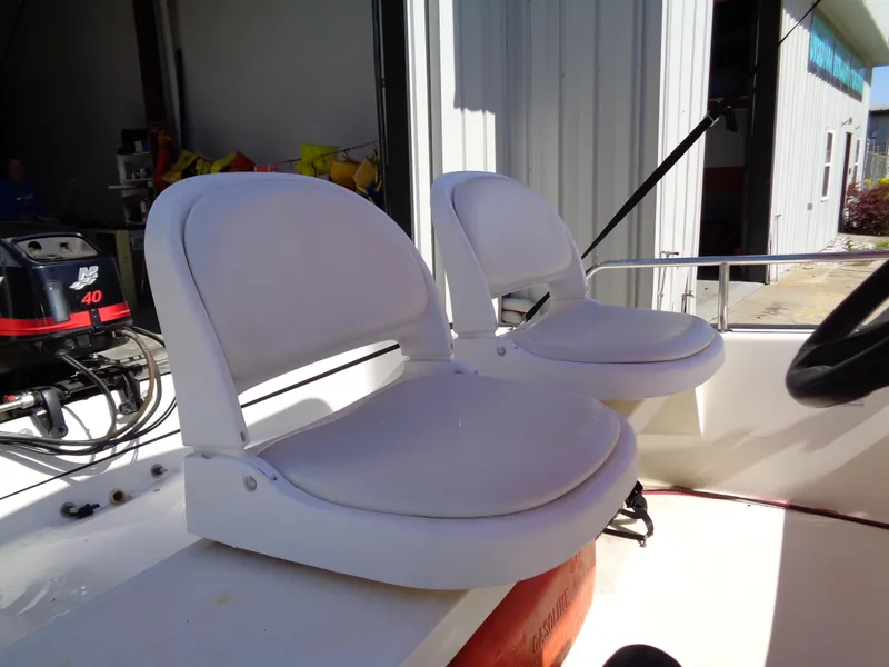 Slide: The Image of 2001 Boston Whaler 13 Sport boat interior with white seats and outboard motor. - 11