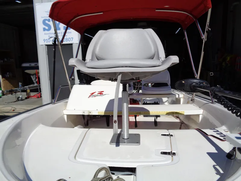 Slide: The Image of 2001 Boston Whaler 13 Sport boat with red canopy and swivel seat. - 3