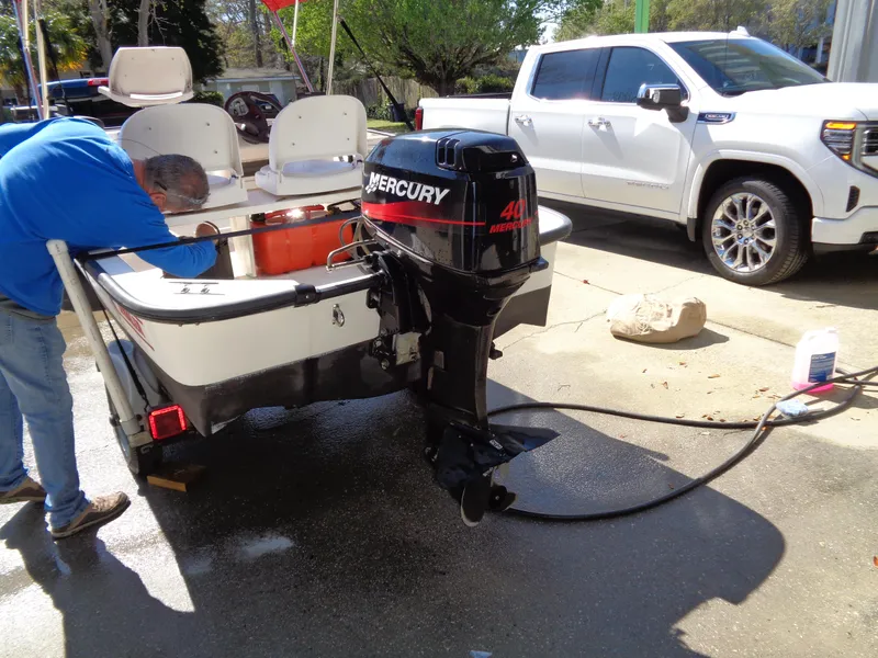 Slide: The Image of Man working on a 2001 Boston Whaler 13 Sport boat with Mercury 40 outboard motor. - 5