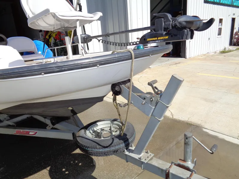 Slide: The Image of 2001 Boston Whaler 13 Sport on trailer with Minn Kota motor, parked outside a building. - 9