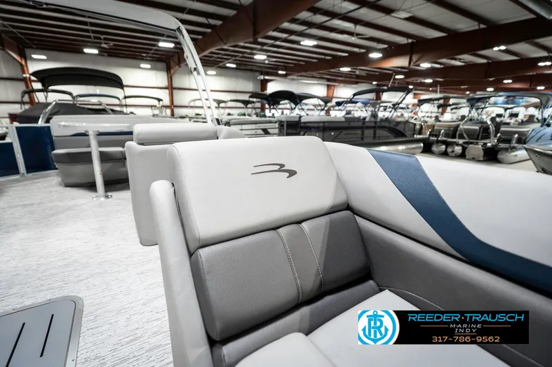 Slide: The Image of 2025 Bennington 23 S CRUISE pontoon boat interior in showroom, featuring sleek seating design. - 23