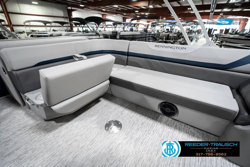 Slide: The Image of 2025 Bennington 23 S Cruise pontoon boat interior with plush seating in showroom. - 28