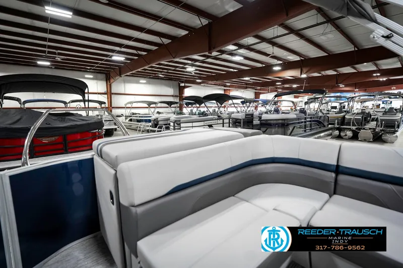 Slide: The Image of 2025 Bennington 23 S CRUISE pontoon boat in a showroom with multiple boats. - 30