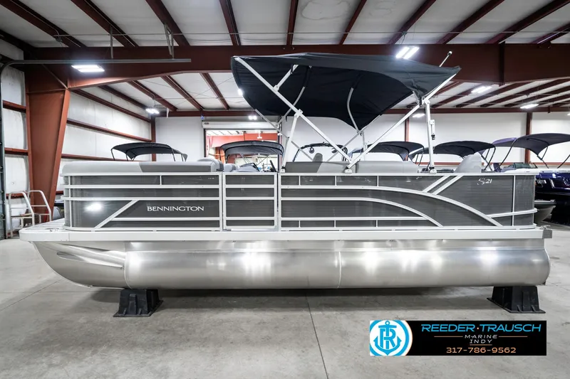 Slide: The Image of 2025 Bennington 21 SS pontoon boat in showroom with canopy and sleek design. - 11