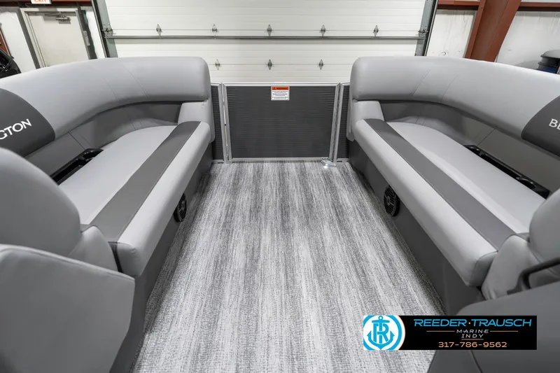 Slide: The Image of 2025 Bennington 21 SS boat interior with gray seating and flooring, showcased by Reeder-Trausch Marine. - 21