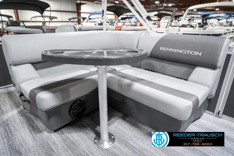 Slide: The Image of 2025 Bennington 21 SS boat interior with gray seating and table in showroom. - 25