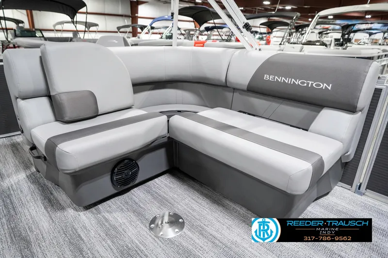 Slide: The Image of 2025 Bennington 21 SS boat interior with gray seating and logo, displayed indoors. - 29