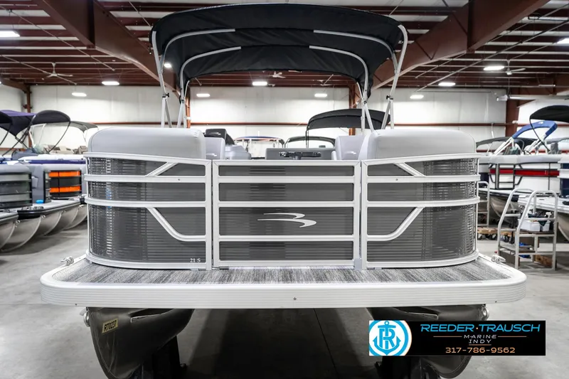 Slide: The Image of 2025 Bennington 21 SS pontoon boat in showroom, front view with canopy. - 5