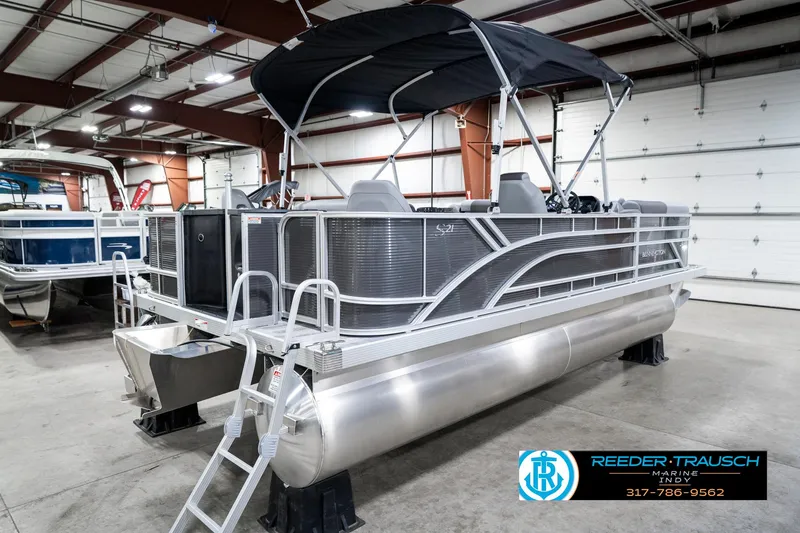 Slide: The Image of 2025 Bennington 21 SS pontoon boat in indoor showroom with canopy and ladder. - 8